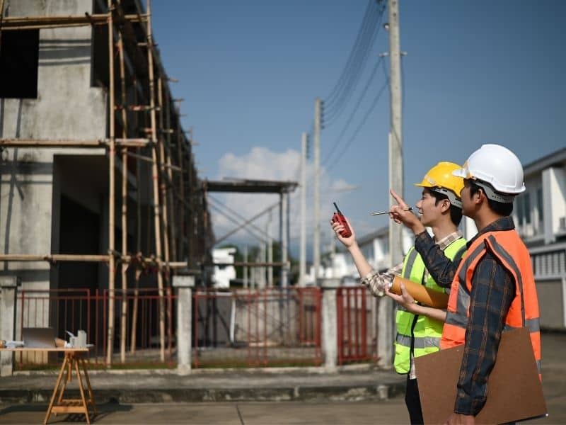 Construction professionals coordinating work on a residential project with homes under development